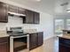 Galley kitchen featuring stainless steel oven with dark cabinets and granite counters at 2620 Abbey Ave, Orlando, FL 32833