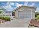 Exterior view of a single-story home with beige siding and a clean, concrete driveway at 2714 Moncayo Ave, The Villages, FL 32162