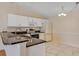 Bright kitchen featuring stainless steel appliances, granite countertops, and white cabinets at 2714 Moncayo Ave, The Villages, FL 32162