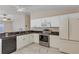 Well-lit kitchen featuring white cabinets and stainless steel appliances at 2714 Moncayo Ave, The Villages, FL 32162