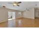 Spacious living room with laminate wood floors, sliding glass doors, and two ceiling fans at 2714 Moncayo Ave, The Villages, FL 32162