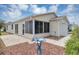 Rear exterior of a beige single-story home with a screened lanai and stone landscaping at 2714 Moncayo Ave, The Villages, FL 32162