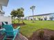 Scenic backyard features vibrant landscaping and charming blue Adirondack chairs near community at 2920 On The Rocks Pt, Kissimmee, FL 34747