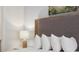 Comfortable bedroom featuring a textured headboard, crisp white linens, and a stylish bedside lamp at 2920 On The Rocks Pt, Kissimmee, FL 34747