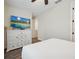Bright bedroom with a large TV mounted above a white dresser and wood-look flooring at 2920 On The Rocks Pt, Kissimmee, FL 34747