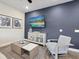 Elegant living room boasting modern furniture, a large TV, and striking blue accent wall at 2920 On The Rocks Pt, Kissimmee, FL 34747