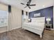 Beautiful bedroom with a white bed, dark blue accent wall, and wood-look flooring at 2920 On The Rocks Pt, Kissimmee, FL 34747