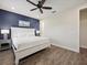 Spacious main bedroom with a white bed, dark blue accent wall, and a ceiling fan at 2920 On The Rocks Pt, Kissimmee, FL 34747