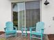Cozy patio area with blue Adirondack chairs and a small table at 2920 On The Rocks Pt, Kissimmee, FL 34747