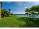 Scenic waterfront backyard view featuring lush grass, palm trees, and serene lake views at 3041 Boating Blvd, Kissimmee, FL 34746