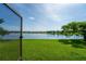 View of a beautiful waterfront backyard featuring lush green grass, a lake, and a picturesque landscape at 3041 Boating Blvd, Kissimmee, FL 34746