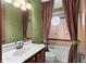 Bathroom with brown curtains, white vanity, a shower, and a round window at 3041 Boating Blvd, Kissimmee, FL 34746