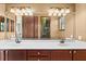 Bathroom with a long mirror, dual sinks, dark wood cabinets, and modern lighting at 3041 Boating Blvd, Kissimmee, FL 34746