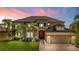 Elegant two-story home featuring lush landscaping, a brick driveway, and a two-car garage at 3041 Boating Blvd, Kissimmee, FL 34746