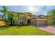 Beautifully landscaped front yard showcasing a luxury home with arched balconies and paver driveway at 3041 Boating Blvd, Kissimmee, FL 34746