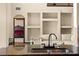 Kitchen sink and island with seating area and a view of the shelves and the living area at 3041 Boating Blvd, Kissimmee, FL 34746
