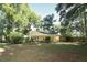 Inviting single-story home with a sunny yellow facade, nestled among mature trees and green lawn at 317 White Oak Dr, Altamonte Springs, FL 32701