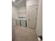 Bright laundry room featuring a modern washer, dryer, wire shelving, and neutral tile flooring at 33836 Sky Blossom Cir, Leesburg, FL 34788