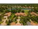 Stunning aerial view of estate home with red tile roof, lush landscaping, and golf course frontage with lake views at 3512 Legacy Hills Ct, Longwood, FL 32779