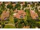 Aerial view of a large estate with a red tile roof, circular driveway, pool, and lush landscaping at 3512 Legacy Hills Ct, Longwood, FL 32779