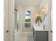 Bright bathroom featuring a large vanity, tub/shower combo, and patterned wallpaper at 3512 Legacy Hills Ct, Longwood, FL 32779