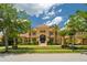 Elegant Mediterranean style estate home featuring manicured lawn, mature palms, and grand double door entry at 3512 Legacy Hills Ct, Longwood, FL 32779