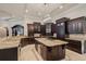 Gourmet kitchen with dark wood cabinets, granite countertops, and a central island with cooktop at 3512 Legacy Hills Ct, Longwood, FL 32779