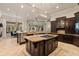 Spacious kitchen featuring dark wood cabinets, granite counters, and an island with a gas cooktop at 3512 Legacy Hills Ct, Longwood, FL 32779
