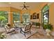 Cozy screened lanai with stone fireplace, TV, ceiling fan and an outdoor furniture set at 3512 Legacy Hills Ct, Longwood, FL 32779