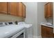 Functional laundry room equipped with modern appliances, sink, and ample cabinet space at 3512 Legacy Hills Ct, Longwood, FL 32779