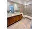 Bathroom featuring double glass vessel sinks, tile shower, and neutral color palette at 3549 Wilshire Way Rd # 56, Orlando, FL 32829
