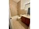 Neutral bathroom with a shower-tub combo, dark wood vanity, and tiled walls at 3549 Wilshire Way Rd # 56, Orlando, FL 32829