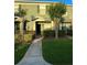 Inviting townhouse with a well-maintained lawn, lush shrubbery, and a sidewalk leading to the front door at 3549 Wilshire Way Rd # 56, Orlando, FL 32829