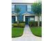 Attractive blue townhome with lush green lawn, manicured shrubs, and a welcoming front entrance at 3549 Wilshire Way Rd # 56, Orlando, FL 32829