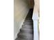 Carpeted staircase with white railing, leading to a bright landing area with tile flooring at 3549 Wilshire Way Rd # 56, Orlando, FL 32829