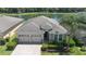 Aerial view of a well-maintained home with a three-car garage, lush landscaping and paver driveway at 4737 Maple Park St, Orlando, FL 32811