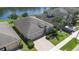 Aerial view of a home showcasing a well-manicured lawn, three-car garage, and waterfront views at 4737 Maple Park St, Orlando, FL 32811