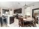 Open kitchen with stainless appliances, dark cabinets, and a wooden dining table at 4737 Maple Park St, Orlando, FL 32811