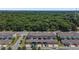 Aerial view of townhomes with attached garages, manicured landscaping, and a lush forest backdrop at 5119 Jones Rd, St Cloud, FL 34771
