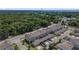 Aerial view of townhomes with well-kept landscaping, parking, and a backdrop of a forest at 5119 Jones Rd, St Cloud, FL 34771