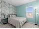 The bedroom showcases a wallpapered accent wall and a window that provides natural light at 5119 Jones Rd, St Cloud, FL 34771