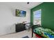 This bedroom has a green accent wall, window, TV, and a single bed at 5119 Jones Rd, St Cloud, FL 34771