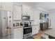 Close-up of kitchen features stainless steel appliances, granite countertops, and white cabinetry at 5119 Jones Rd, St Cloud, FL 34771