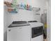 Bright laundry room with washer, dryer, and shelving for storage of supplies at 5119 Jones Rd, St Cloud, FL 34771