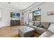 Bright living room featuring wood floors, tray ceiling, and a gray sectional sofa with a large window at 5119 Jones Rd, St Cloud, FL 34771