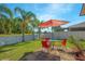 Outdoor patio with seating and views of the grassy backyard, palm trees, and waterfront at 5151 Preserve Blvd, St Cloud, FL 34772