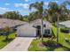 Inviting single-story home with lush lawn, mature landscaping, and a convenient two-car garage at 5560 Squires Dr, Leesburg, FL 34748