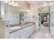 Modern bathroom with double sinks, granite countertops, and access to the bedroom via a doorway at 5560 Squires Dr, Leesburg, FL 34748