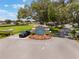 Royal Highlands entrance, showcasing mature trees, colorful flowers, and meticulous landscaping at 5560 Squires Dr, Leesburg, FL 34748