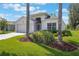 Inviting single-story home featuring a manicured lawn, mature landscaping, and a two-car garage at 5560 Squires Dr, Leesburg, FL 34748